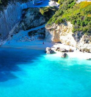 an aerial view of a beach with blue water