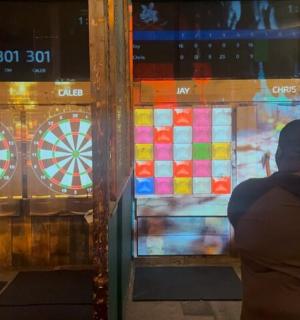 a person standing in front of a window with a dartboard