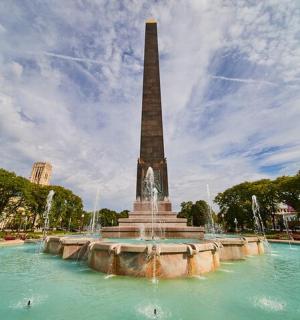 a fountain with a tall obelisk in a park
