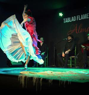 一名女子撑着伞在舞台上跳舞