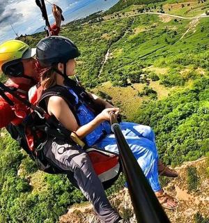 a man and a woman on a zip line over a mountain