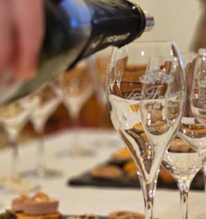 žmogus, pilantis vyną į vyno taures ant stalo