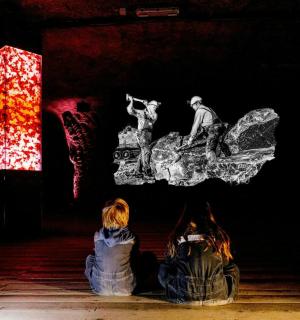 two people sitting on the floor in front of a stage