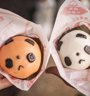 一个人拿着两个画着人脸的甜甜圈