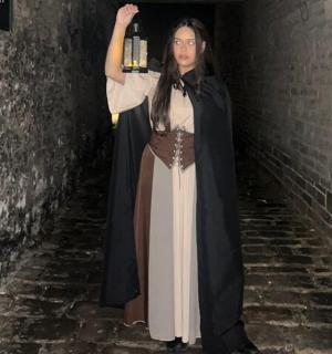 eine als Hexe verkleidete Frau, die in einem Tunnel steht