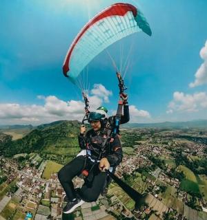 a man flying with a parachute in the air