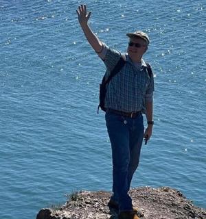 一名男子站在岩石上,举起双手