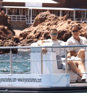 two men sitting on a boat in the water