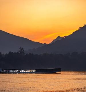 a boat on the water with a sunset in the background