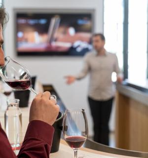 muž sedící u stolu se sklenkou vína