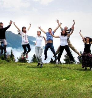 skupina lidí skákajících na vrcholu kopce