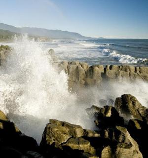 a wave crashing on the rocks near the ocean