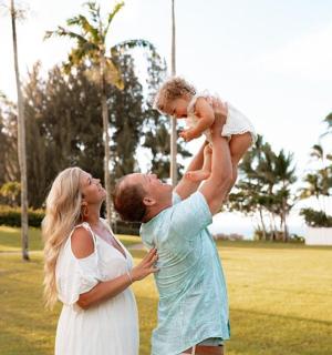 一名男子和一名女子抱着一个孩子