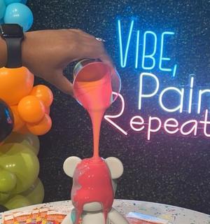 a person holding a wine glass next to a table with balloons