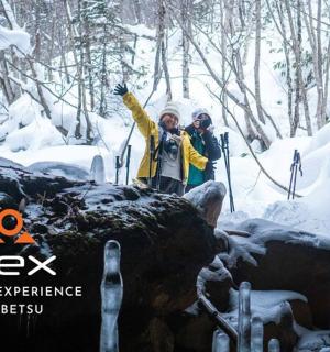 两个人站在雪地里的一块岩石上