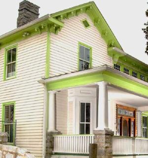 an old white house with a green roof