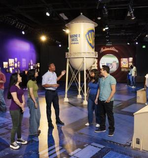 一群人站在房间里,身边放着一个花瓶