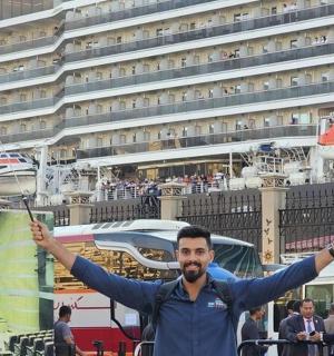 muž držící dvě vlajky před výletní lodí