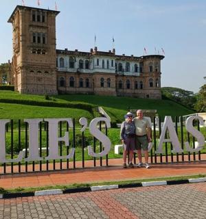 คนสองคนยืนอยู่หน้าป้ายหน้าปราสาท