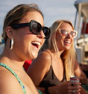 two women in sunglasses sitting on a boat