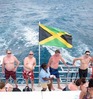 一群人站在船上，手里拿着一面旗帜