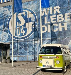 ein kleiner Lieferwagen, der vor einem Gebäude geparkt ist