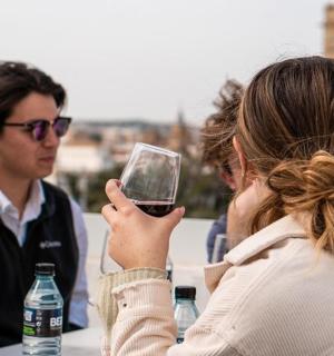 a group of people sitting at a table with a glass of wine