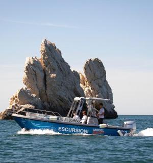 Modrá loď ve vodě poblíž skalního útvaru