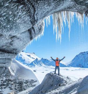 一名男子站在冰洞前