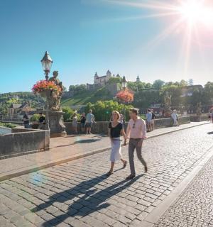 ein Paar geht eine Straße vor einem Schloss entlang