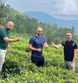 a group of three men standing in a field