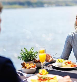 a man and a woman sitting at a table eating food