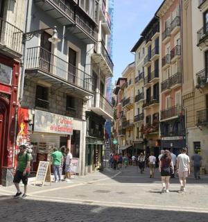 a group of people walking down a street with buildings