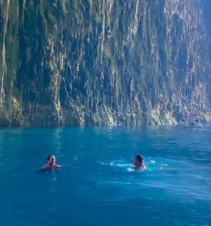 two people swimming in the water near a boat