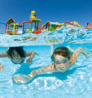 两个孩子在水上乐园的游泳池里游泳