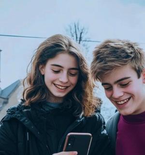 a man and a woman looking at a cell phone