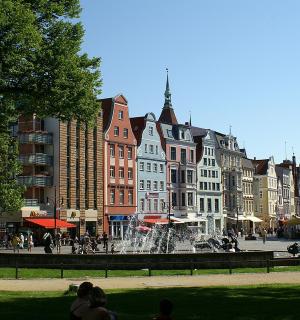 a group of buildings in a city with a fountain