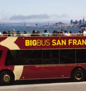 a red double decker bus driving down a street