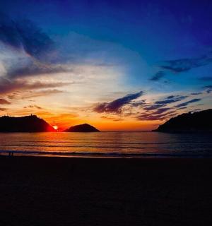 una posta de sol a la platja amb l'oceà i el cel