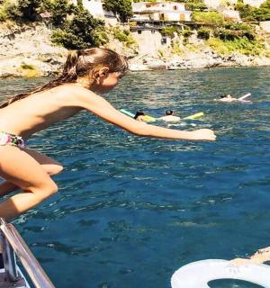 a young girl standing on a boat in the water