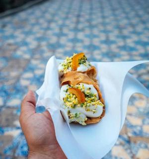 一个人拿着纸包装的热狗