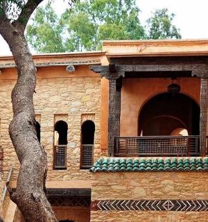 pastatas su balkonu ir medžiu