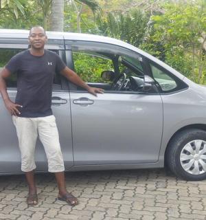 a man standing next to a silver van