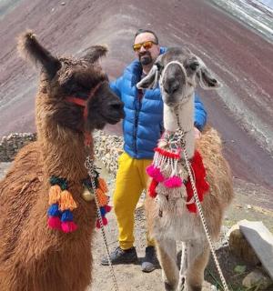 muž stojící vedle dvou lam na hoře