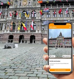 a person holding up a cell phone in front of a building