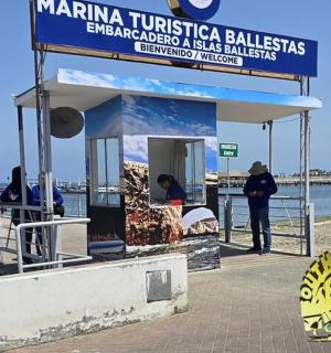 a man standing next to a kiosk on a pier