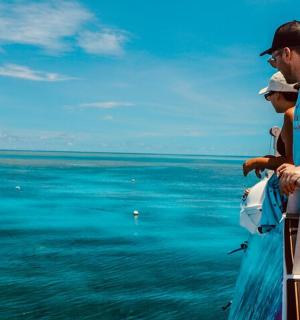 dva muži stojící na lodi a dívající se na oceán