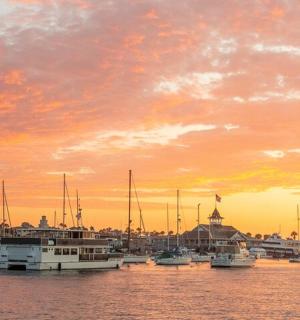 Skupina lodí zakotvených v přístavu při západu slunce