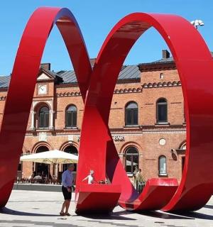 a large red sculpture in front of a building