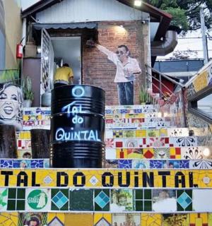 一名男子站在一栋有壁画的建筑的楼梯上